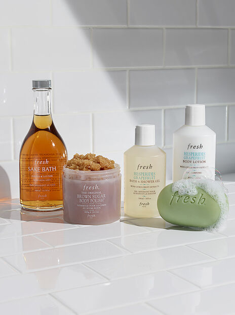 Lineup of fresh Sake Bath Soak, body scrub, shower gel and body lotion and bar soap