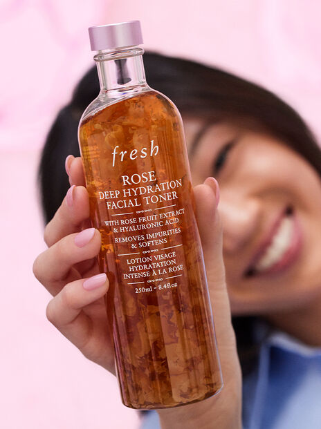 Close up of a smiling woman holding Rose Toner