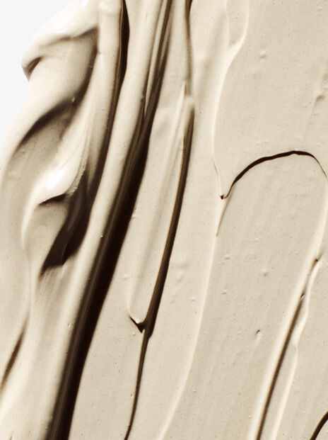 close up of beige clay smeared across a white background