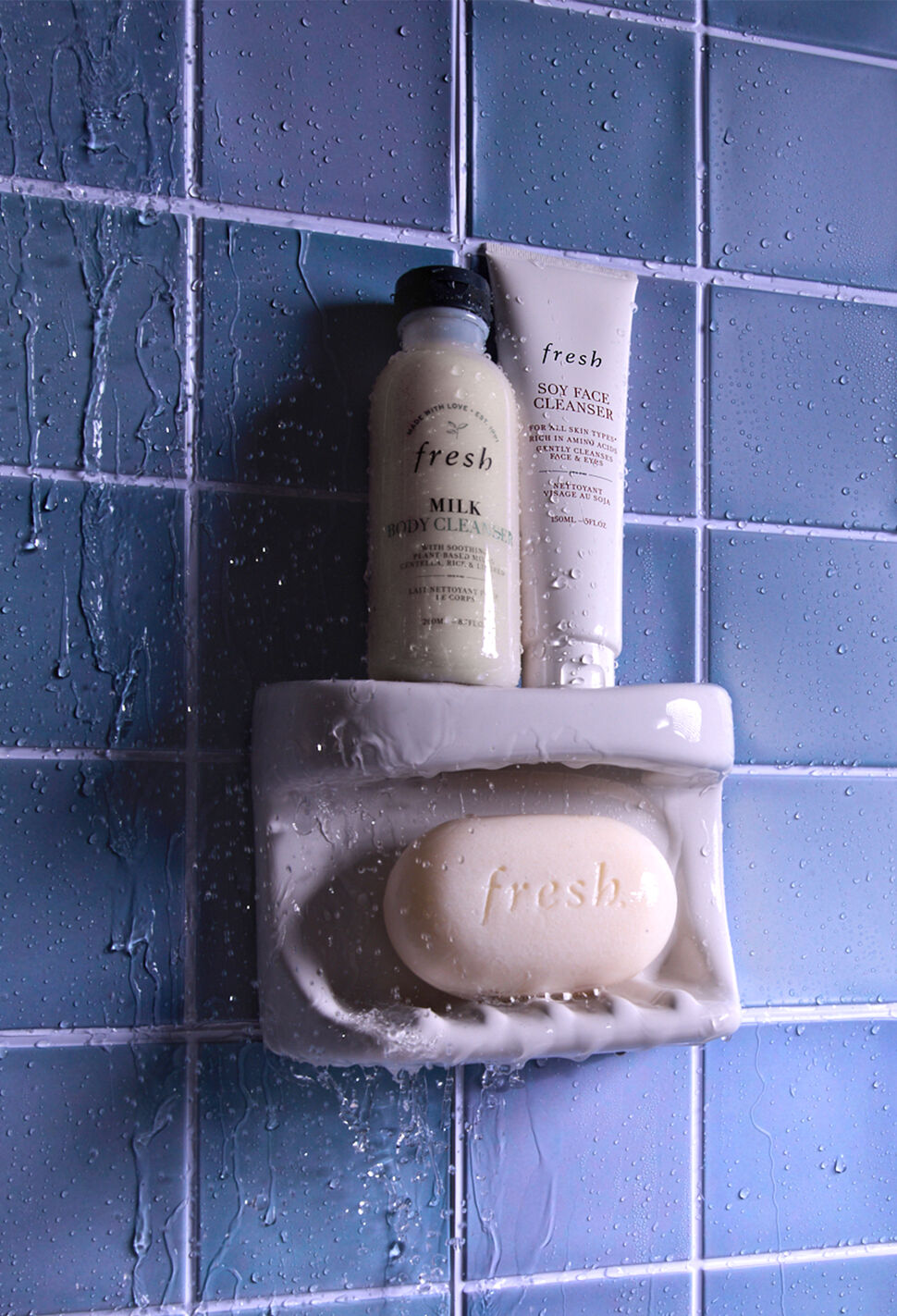 fresh bar soap, Milk Cleanser and Soy Face Cleanser against blue tile