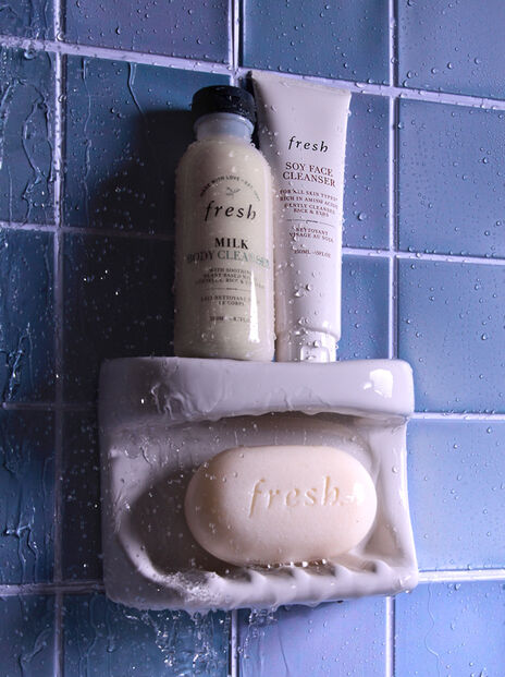 fresh bar soap, Milk Cleanser and Soy Face Cleanser against blue tile