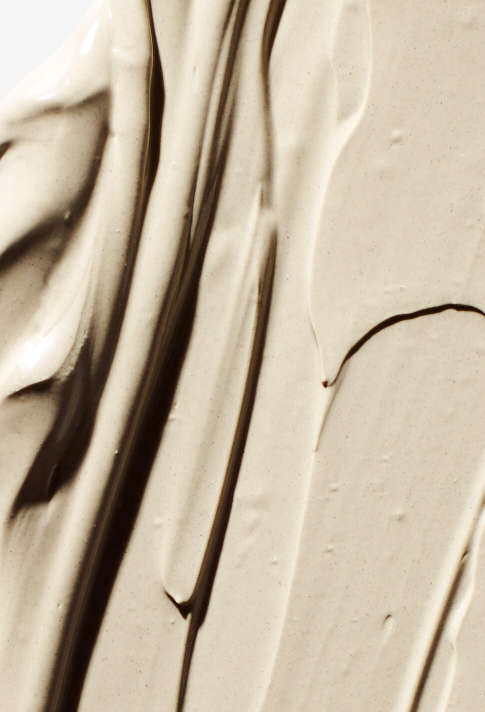 close up of beige clay smeared across a white background
