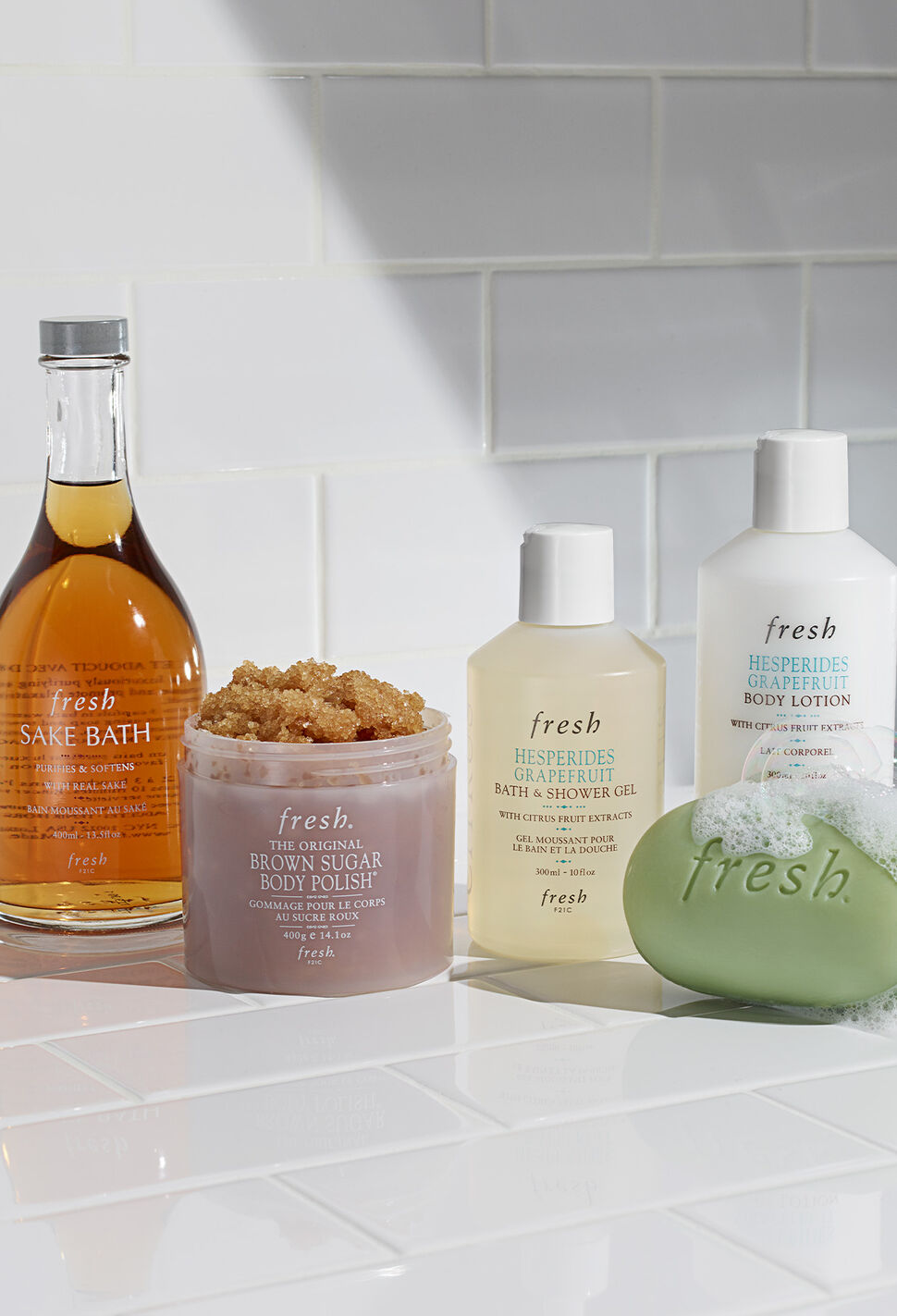 Lineup of fresh Sake Bath Soak, body scrub, shower gel and body lotion and bar soap