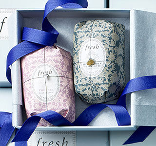 Two Fresh soap bars inside a Fresh gift box with violet-coloured ribbon